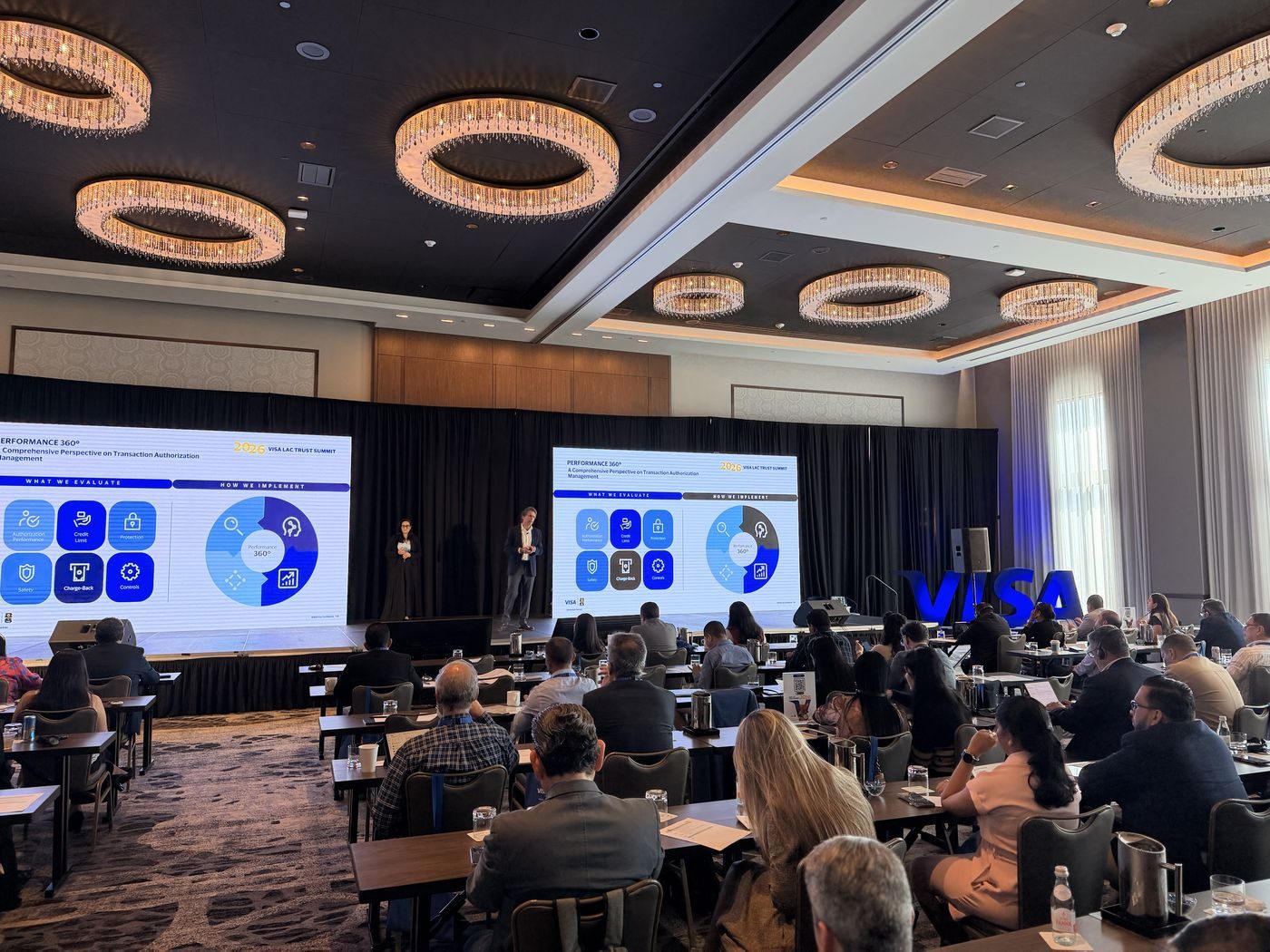 Corporate summit session with attendees and stage screens