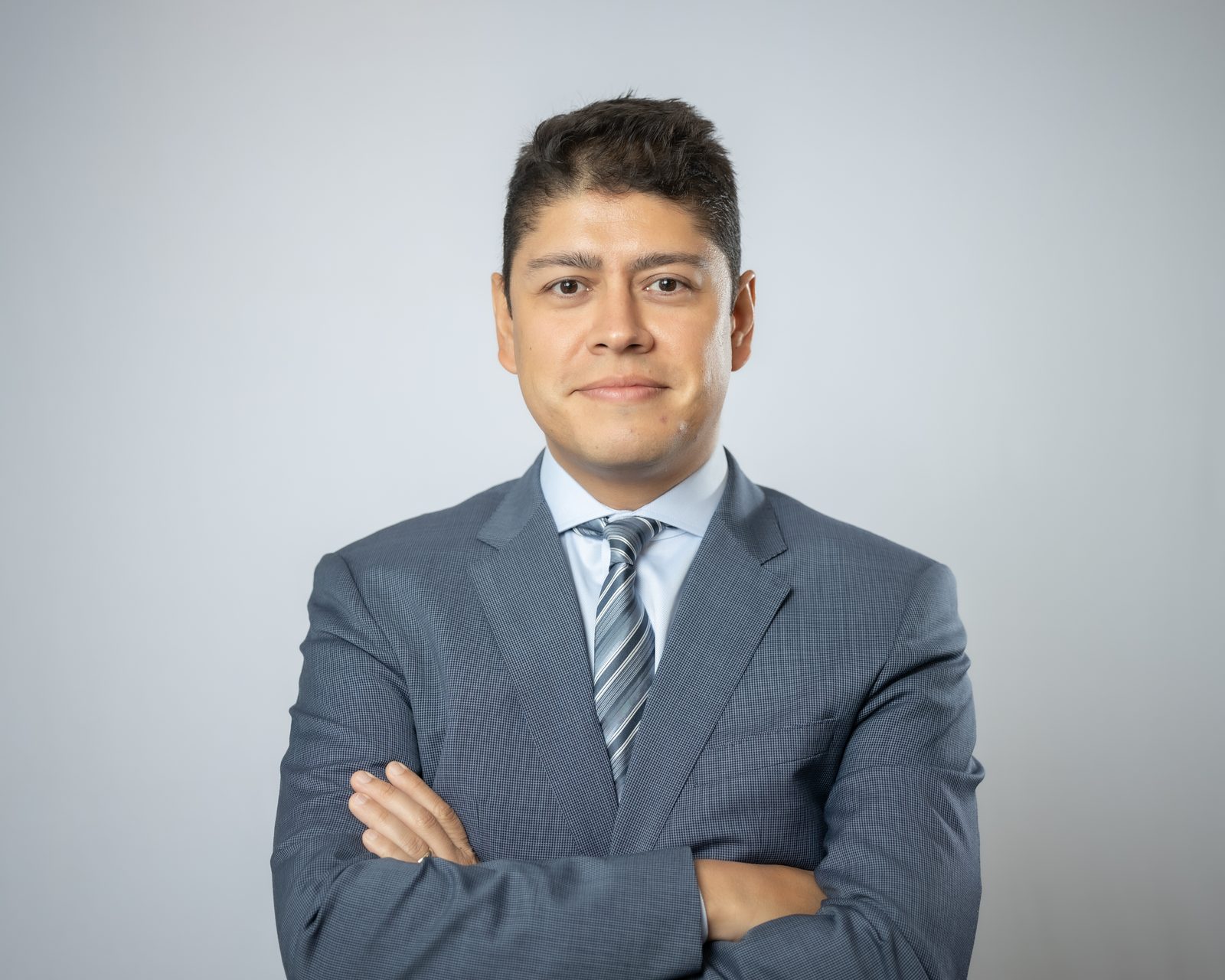 Business headshot of a man in a suit on a light gray backdrop