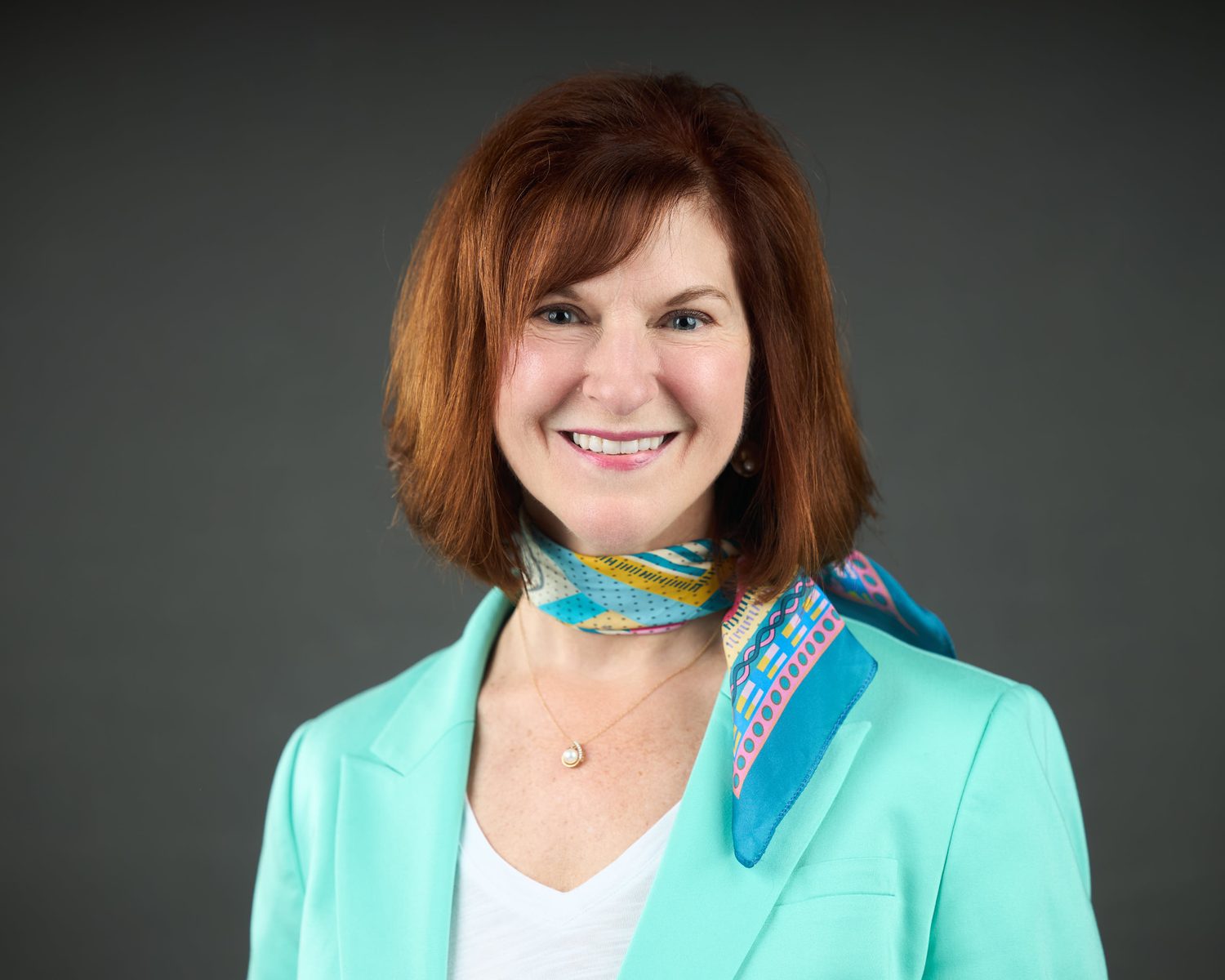 Professional headshot of a business leader on a dark background