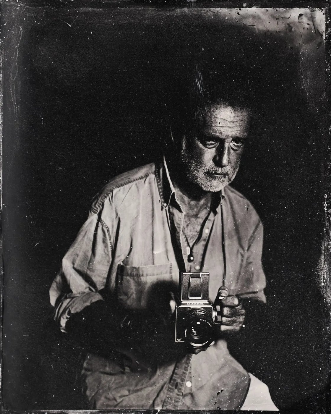 Tintype portrait of a photographer holding a camera